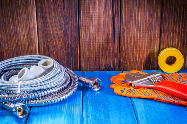 Forniture idrauliche e strumenti su uno sfondo di legno blu da vicino
. - Foto, immagini