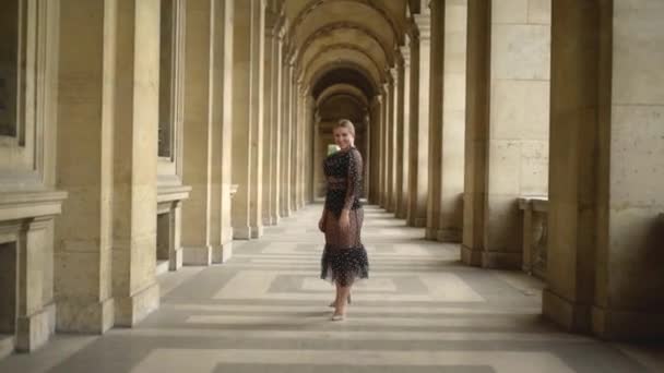 Вид сзади на сексуальную молодую женщину, гуляющую по старому зданию. Начали. Привлекательная молодая женщина в соблазнительно раскрывающемся прозрачном платье - образцовая походка по коридору старого здания
 - Кадры, видео