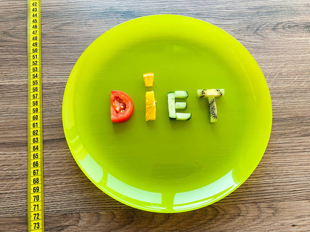 Word diéta készült szeletelt zöldségek tányéron mérésével fa háttér - Fotó, kép