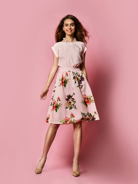 Cute slender girl in red dress for a date - a blouse and a fluffy skirt posing in the studio on a pink background. to meet spring and summer. Wardrobe update - Foto, Imagem