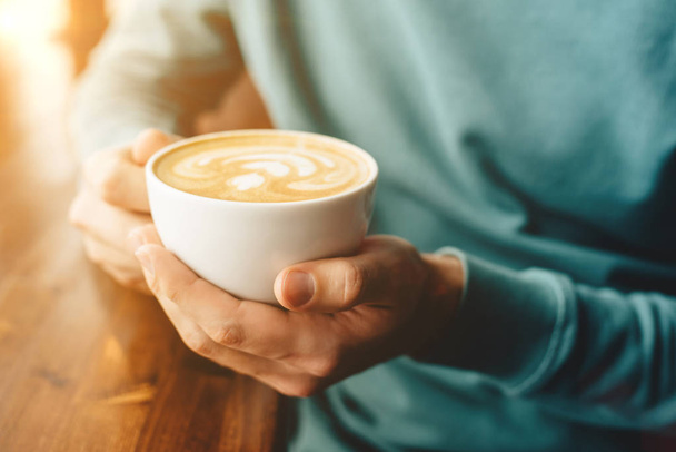 The cup of cappuccino in mens hands - Photo, Image