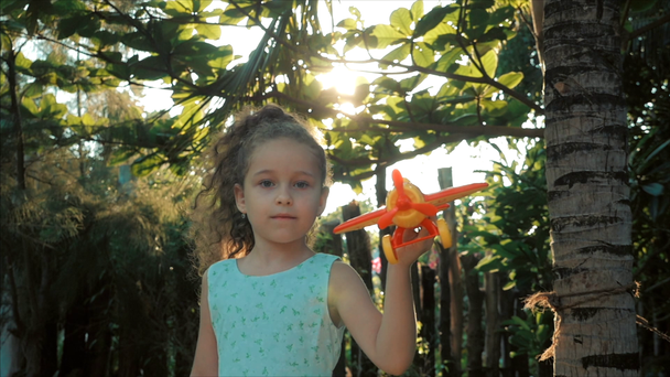 glückliches Kind rennt mit einem Spielzeugflugzeug vor Sonnenuntergang. - Filmmaterial, Video