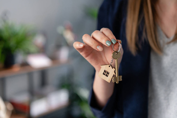 Concept of renting an apartment. House key in womans hands. Young woman. Modern light lobby interior. Real estate, hypothec, moving home or renting property. - Foto, Imagen