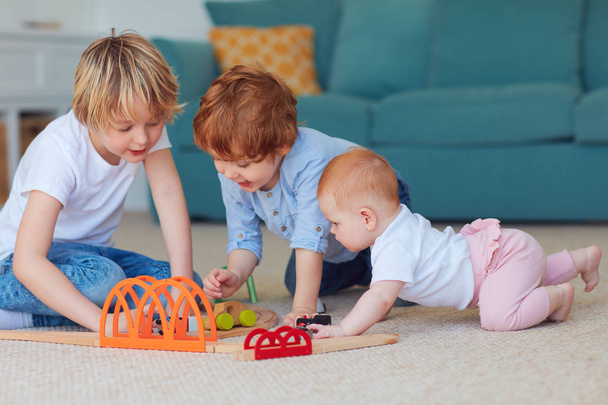 cute kids, siblings playing toys together on the carpet at home - 写真・画像