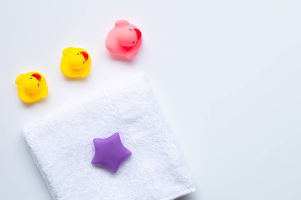 Roze en gele eend speelgoed en witte handdoek. Kids Bath concept. - Foto, afbeelding