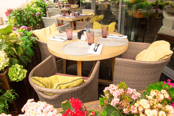 Yazlık teras kafe, restoran. Masa sandalyeleri düzgünce düzenlenir ve misafirlere servis edilir.. - Fotoğraf, Görsel