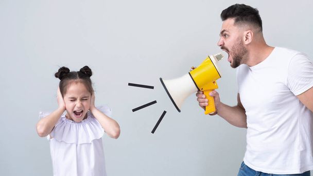 Wütender Vater schreit seine Tochter mit Megafon an - Foto, Bild