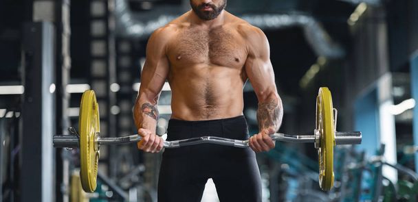 muskulöser Mann mit nacktem Oberkörper trainiert hart mit schwerer Langhantel - Foto, Bild