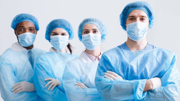 Surgeons Team. Doctors Wearing Protective Uniform, Look At Camera - Foto, imagen