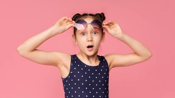 Zaskoczona dziewczynka rosnące okulary przeciwsłoneczne w zdumienie - Zdjęcie, obraz