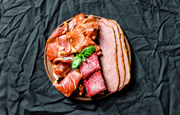 Italialainen kylmä liha antipasti delicatessen lautanen mustaa taustaa vasten
 - Valokuva, kuva