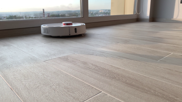 Mądry dom. Robot odkurzacz wykonuje automatyczne sprzątanie mieszkania w określonym czasie - Materiał filmowy, wideo
