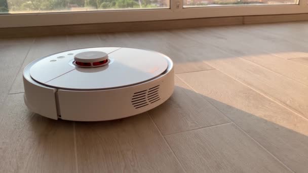 Smart Home. Staubsaugerroboter führt die automatische Reinigung der Wohnung zu einer bestimmten Zeit durch - Filmmaterial, Video