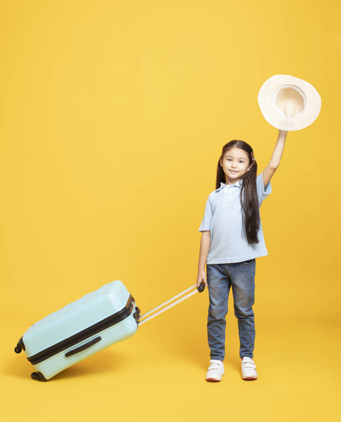 happy little girl with suitcase going on vacation - Fotó, kép