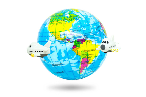 Concepto de viaje y vacaciones: Avión volando alrededor del mundo aislado sobre fondo blanco
. - Foto, Imagen