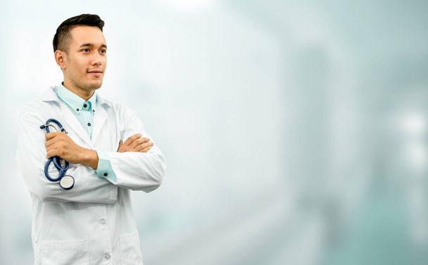 Άντρας γιατρός στέκεται στο γραφείο του νοσοκομείου. - Φωτογραφία, εικόνα