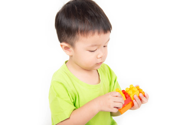 Kleiner Junge Kleinkind spielt Plastik-Ziegelstein bunt mit glücklich - Foto, Bild