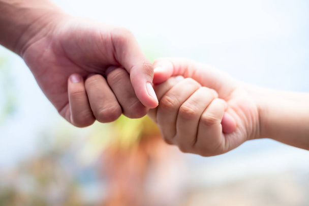 Close up shot of two hands one of father and daughter with blurred background. Concept of Fathers day and taking care of female child, Helping to conquer fear and obstacles in practical life. - Φωτογραφία, εικόνα