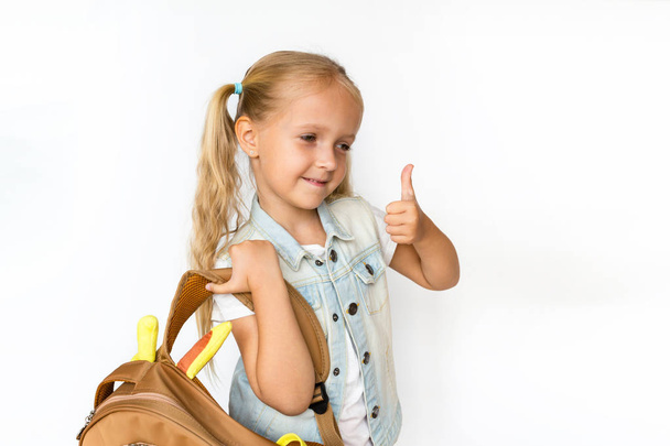 Back to school and happy time. Cute child with blonde hair on white background. Kid with backpack. Girl ready to study. Mockup, place for text, education concept - Photo, image