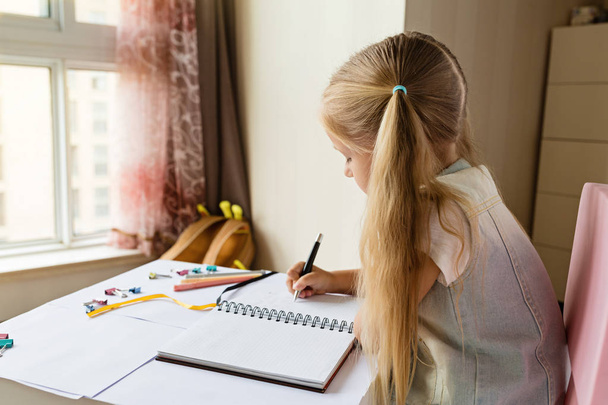 Back to school and happy time. Children holding pen and writting in notebook. Kid making homework. education concept - Фото, изображение