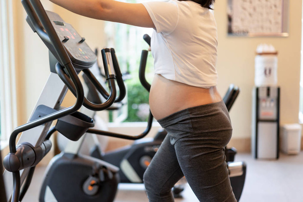 Active pregnant woman exercise in fitness center. - Fotoğraf, Görsel