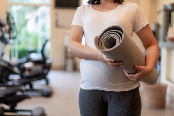 Aktive Schwangere trainieren im Fitnessstudio. - Foto, Bild