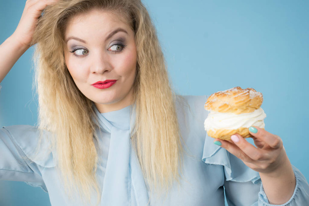 Funny woman holds cream puff cake - Photo, image