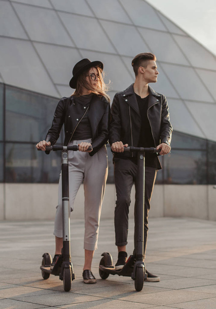 Romantic casual couple on scooters are riding in the city - 写真・画像