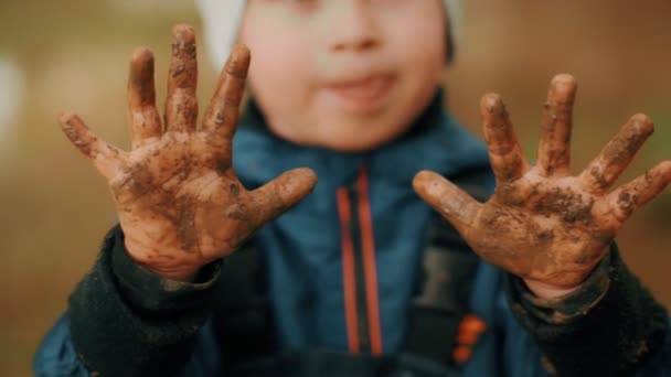 Close-up weinig speelse jongen tonen vies in grond handen ondeugende kind genieten van Happy Childhood - Video