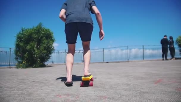 岸壁のペニーボードでスケートをする男 - 映像、動画