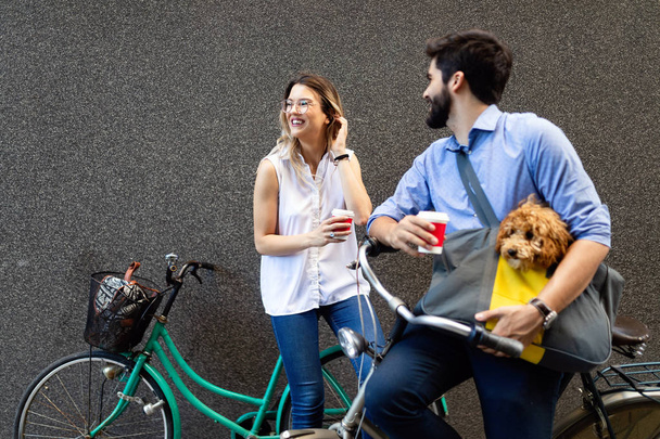Attractive woman and handsome man spending time together with dog and bicycles - Фото, изображение