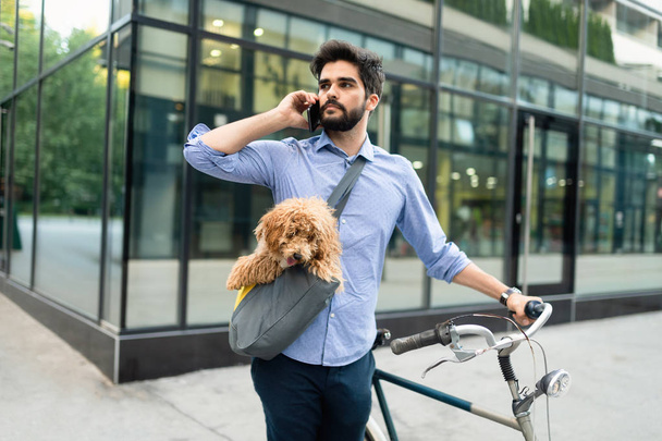 Lifestyle, communication and people concept. Young man with bicycle and smartphone on city street - Photo, Image
