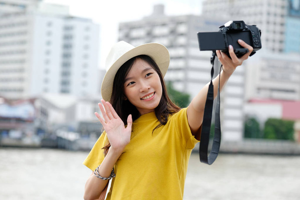 jong schattig aziatisch vrouw in casual stijl met behulp van camera naar selfie in - Foto, afbeelding