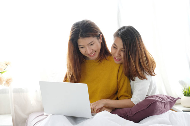 Young cute asia lesbian couple using laptop with happiness at ho - Photo, image