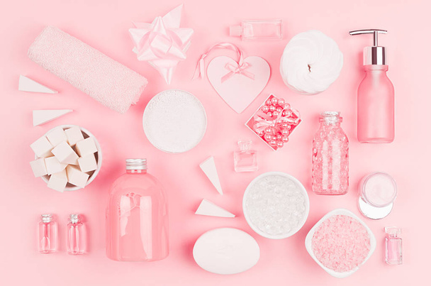 Cosmetic products for bathroom, health and hygiene in modern girlish style - decorative heart, soap, bath salt, essential oil, cream, towel, perfume, pearls, gift box on pink background. - Photo, Image