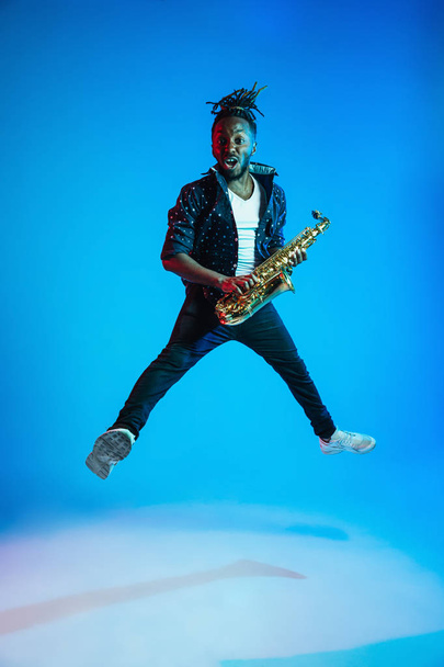 Young african-american jazz musician playing the saxophone - Foto, afbeelding