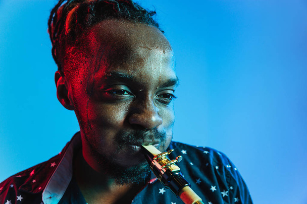 Νέος αφροαμερικανός μουσικός τζαζ που παίζει σαξόφωνο - Φωτογραφία, εικόνα