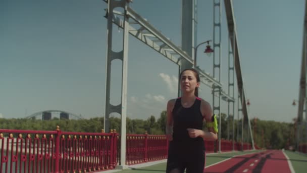 Asian female jogger running on pedestrian bridge - Imágenes, Vídeo