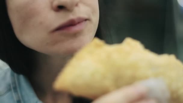 Close-up hungry woman chewing at food court unhealthy fried and fatty food in shopping mall. Young woman eating cheap snack at fast food restaurant. Eating tasty meal, addicted to calorie junk food.  - Materiał filmowy, wideo