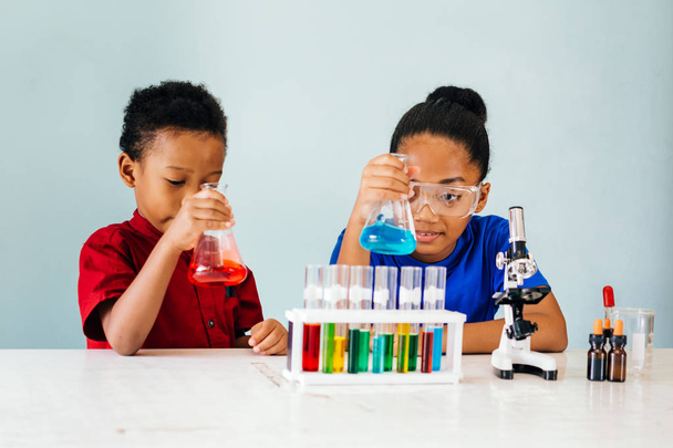 Curious black children experimenting in school chemistry laboratory - Valokuva, kuva