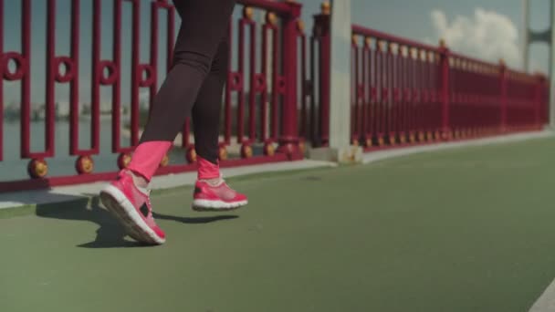 Legs of fit female athlete running on city bridge - Filmagem, Vídeo