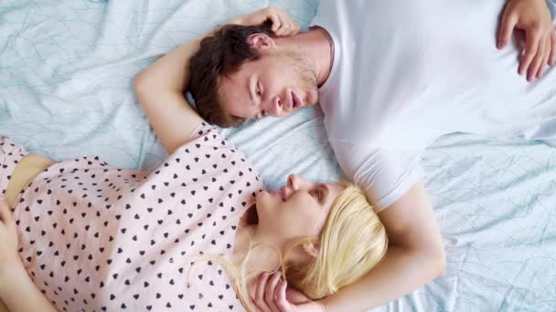 top down spinning over romantic couple lying in bed face to face in the morning - Footage, Video