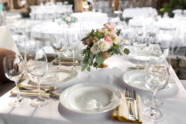Wedding table setting decorated with fresh flowers in a brass va - Zdjęcie, obraz