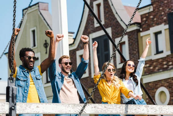 joyeux groupe d'amis multiculturels dans des lunettes de soleil célébrant triomphe
  - Photo, image