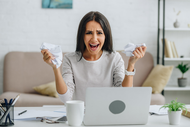 screaming and attractive woman looking at camera and holding papers  - Photo, Image