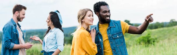 panoráma szemcsésedik-ból boldog afrikai amerikai ember mutatva-val ujj rövid idő álló-val lány mellett barátok  - Fotó, kép