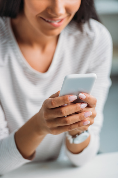cropped view of young adult woman using smartphone in apartment  - Photo, Image