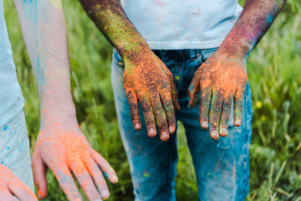 cropped view of african american man and woman with holi paints on hands - Fotografie, Obrázek