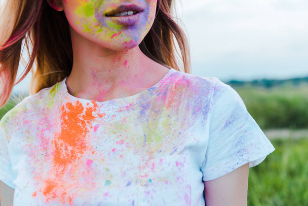 vista recortada de la mujer con coloridas pinturas holi en la cara
  - Foto, imagen