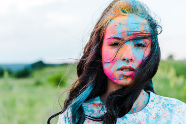 vonzó fiatal nő színes Holi festékek nézett kamera  - Fotó, kép